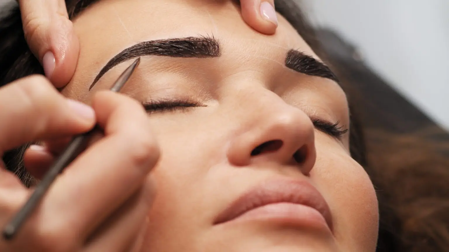 Woman is on the Eyebrow coloring procedure. Beauty care concept.